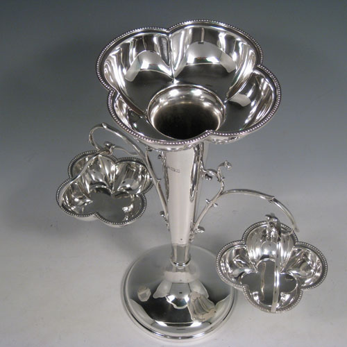 Sterling silver table epergne, having a central vase for flowers, with two removable hanging side baskets, with applied bead borders, and sitting on a pedestal foot. Made by William Hutton and Sons of Sheffield in 1923. Height 30 cms (11.75 inches), width 26 cms (10.25 inches). Total weight approx. 632g (20.4 troy ounces).   