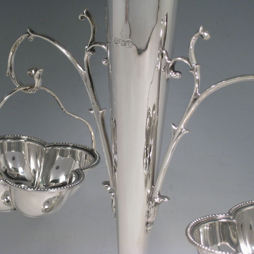 Sterling silver table epergne, having a central vase for flowers, with two removable hanging side baskets, with applied bead borders, and sitting on a pedestal foot. Made by William Hutton and Sons of Sheffield in 1923. Height 30 cms (11.75 inches), width 26 cms (10.25 inches). Total weight approx. 632g (20.4 troy ounces).   