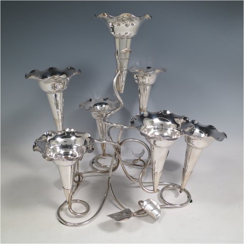 An Antique Victorian silver plated Art Nouveau flower vase epergne center-piece, having seven removable flower vases, with a tendril and leaf style body. All made in ca. 1890. The dimensions of this fine hand-made silver-plated flower epergne are height 30.5 cms (12 inches), and spread across vases 33 cms (13 inches).   