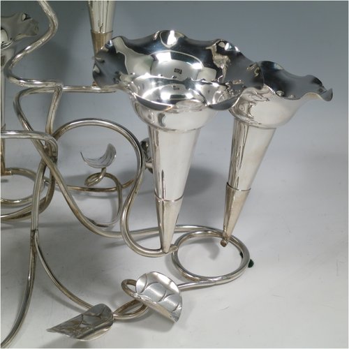 An Antique Victorian silver plated Art Nouveau flower vase epergne center-piece, having seven removable flower vases, with a tendril and leaf style body. All made in ca. 1890. The dimensions of this fine hand-made silver-plated flower epergne are height 30.5 cms (12 inches), and spread across vases 33 cms (13 inches).   