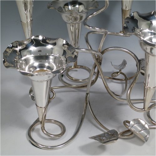 An Antique Victorian silver plated Art Nouveau flower vase epergne center-piece, having seven removable flower vases, with a tendril and leaf style body. All made in ca. 1890. The dimensions of this fine hand-made silver-plated flower epergne are height 30.5 cms (12 inches), and spread across vases 33 cms (13 inches).   