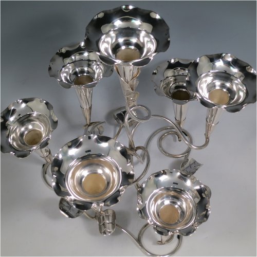 An Antique Victorian silver plated Art Nouveau flower vase epergne center-piece, having seven removable flower vases, with a tendril and leaf style body. All made in ca. 1890. The dimensions of this fine hand-made silver-plated flower epergne are height 30.5 cms (12 inches), and spread across vases 33 cms (13 inches).   