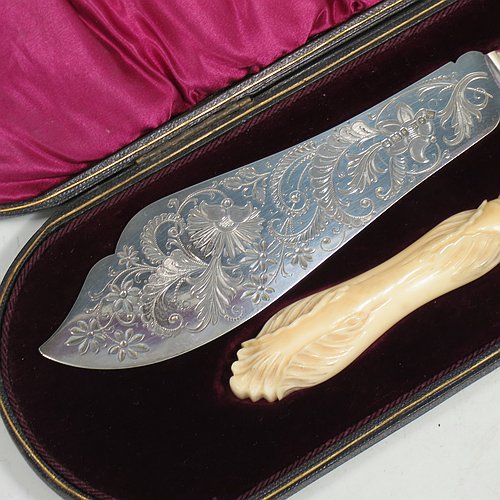 An Antique Victorian Sterling Silver fish serving knife and fork set, having hand-carved bone handles, with hand-engraved blade and tines with floral decoration, all in their original maroon satin and velvet-lined presentation box. Made by Robert Fead Mosley of Sheffield in 1894. The dimensions of this fine hand-made antique silver and bone-handled fish serving set are length of knife 32 cms (12.5 inches), and length of fork 24 cms (9.5 inches).   