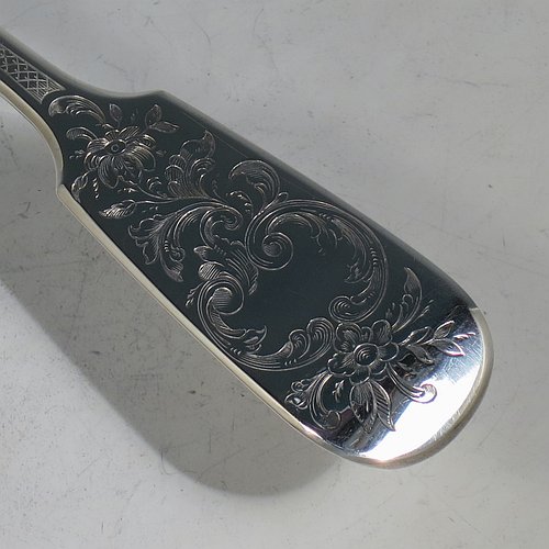 A very pretty Antique Victorian Sterling Silver fish server slice, in the Fiddle pattern with hand-engraved floral decoration on the upper side, and a hand-pierced asymmetrical and curved blade. Made by Elizabeth Eaton of London in 1846. The dimensions of this fine hand-made antique silver fish serving slice are length 32 cms (12.5 inches), and it weighs approx. 168g (5.4 troy ounces).    