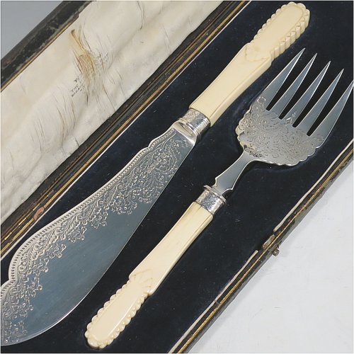 An Antique Victorian Sterling Silver fish serving knife and fork set, having hand-carved bone or ivory handles, with hand-engraved blade and tines with floral decoration, all in their original satin and blue velvet-lined presentation box. Made by James Deakin & Sons of Sheffield in 1887. The dimensions of this fine hand-made antique silver fish serving set are length of knife 31 cms (12.25 inches), and length of fork 24 cms (9.5 inches). Please note that the cream coloured satin upper lining to the lid is slightly damaged.    