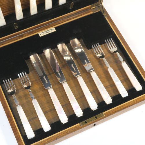 A very elegant Art Deco style Sterling Silver and mother of pearl handled fish eating set for eight people, having plain blades and tines, and with hand-cut mother-of-pearl handles, all fitted into their original black velvet-lined oak presentation box. This stylish Art Deco silver and mother-of-pearl fish set was all made by Wilson and Gill  of Sheffield in 1933. The dimensions of these fine hand-made silver and mother of pearl fish-eaters are length of knife 18 cms (7 inches), and fork 15 cms (6 inches).  