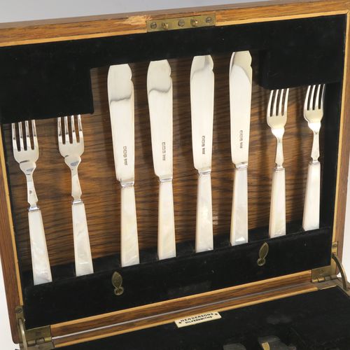 A very elegant Art Deco style Sterling Silver and mother of pearl handled fish eating set for eight people, having plain blades and tines, and with hand-cut mother-of-pearl handles, all fitted into their original black velvet-lined oak presentation box. This stylish Art Deco silver and mother-of-pearl fish set was all made by Wilson and Gill  of Sheffield in 1933. The dimensions of these fine hand-made silver and mother of pearl fish-eaters are length of knife 18 cms (7 inches), and fork 15 cms (6 inches).  