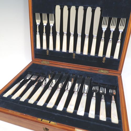 A very pretty Antique Sterling Silver and mother of pearl handled fish set for twelve people, having plain blades and tines, and with hand-cut mother-of-pearl handles, all fitted into their original dark blue velvet-lined oak presentation box. All made by John Sanderson of Sheffield in 1912. The dimensions of these fine hand-made antique silver and mother of pearl fish-eaters are length of knife 19 cms (7.5 inches), and fork 16 cms (6.3 inches).   