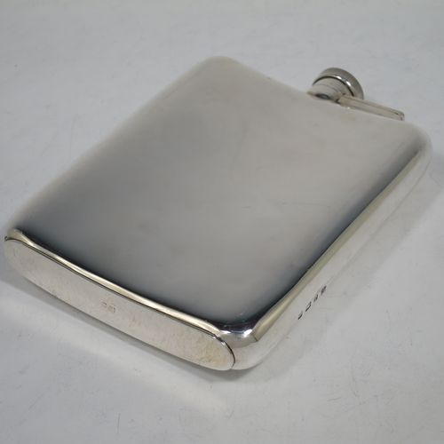 A large and handsome Sterling Silver whisky hip flask, having a plain shaped rectangular body with rounded shoulders, and a bayonet-fit lid with knurled edge. Made by William Neale Ltd., of Birmingham in 1924. The dimensions of this fine hand-made silver hip whisky flask are length 15 cms (6 inches), width 11 cms (4.25 inches), depth 2 cms (0.75 inch), and it weighs approx. 226g (7.3 troy ounces). Please note that this item is crested on one side.