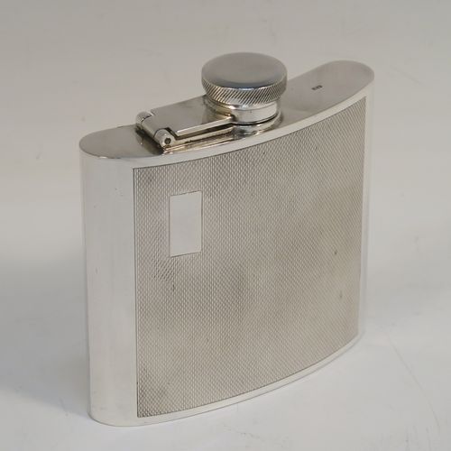 A handsome Sterling Silver whisky flask, having a square curved body with rounded sides, a plain flat top and base, and a hinged and bayonet-fit lid with knurled top, and engraved with engine-turning. This elegant silver flask was made by Garrards and Co., of London in 1974. The dimensions of this fine hand-made silver whisky hip flask are height 10 cms (4 inches), width 10 cms (4 inches), depth 2 cms (0.75 inch), and it weighs approx. 217g (7 troy ounces).  