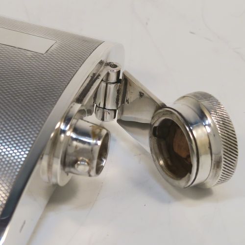 A handsome Sterling Silver whisky flask, having a square curved body with rounded sides, a plain flat top and base, and a hinged and bayonet-fit lid with knurled top, and engraved with engine-turning. This elegant silver flask was made by Garrards and Co., of London in 1974. The dimensions of this fine hand-made silver whisky hip flask are height 10 cms (4 inches), width 10 cms (4 inches), depth 2 cms (0.75 inch), and it weighs approx. 217g (7 troy ounces).  