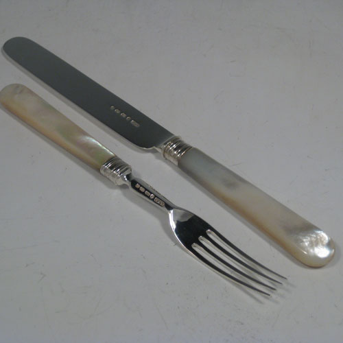 Antique Victorian sterling silver and mother-of-pearl handled fruit set for 12 people. Having plain parallel bladed knives and plain four-prong forks, reeded ferrules connecting the mother-of-pearl handles, and fitted into an original oak canteen with removable top tray and blue velvet interior. Made by Thomas Prime and Sons of Birmingham between 1865 and 1870. Length of knife 20 cms (8 inches), length of fork 17 cms (6.75 inches)