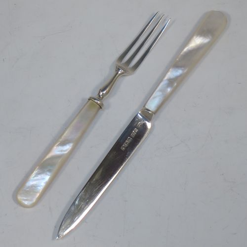 A very elegant Antique Sterling Silver and mother-of-pearl handled fruit set for twelve people. Having plain straight-sided pointed-end blade knives, and three-prong forks. All fitted into an original presentation box with cream satin and dark blue velvet interior. Made by James Dixon and Sons of Sheffield in 1925. The dimensions of this fine hand-made antique silver fruit service are length of knife 19 cms (7.5 inches), and the length of the fork 13.5 cms (5.25 inches).  