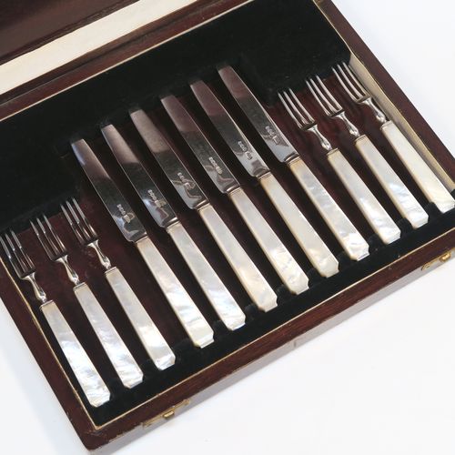 A very elegant Art Deco style Sterling Silver and mother-of-pearl handled fruit set for six people. Having plain straight-sided pointed-end blade knives, and three-prong forks. All fitted into an original wooden presentation box with black velvet-lined interior. This handsome silver fruit set was made by James Dixon and Sons of Sheffield in 1934. The dimensions of this fine hand-made silver and mother-of-pearl fruit service are length of knife 17 cms (6.75 inches), and the length of the fork 13.5 cms (5.3 inches).   