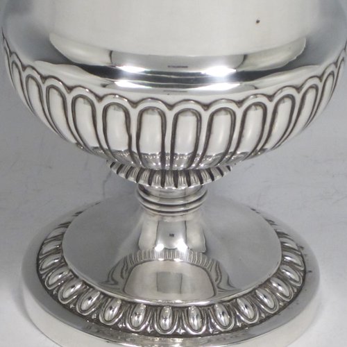 Antique Georgian sterling silver Regency goblet, having a hand-chased campagna style body, with an applied band of grapevine decoration, a half-fluted lower body, and sitting on a pedestal foot. Made in London in 1812. The dimensions of this fine hand-made silver goblet are height 15 cms (6 inches), diameter at lip 10 cms (4 inches), and it weighs approx. 386g (12.5 troy ounces).   