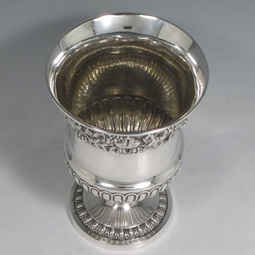 Antique Georgian sterling silver Regency goblet, having a hand-chased campagna style body, with an applied band of grapevine decoration, a half-fluted lower body, and sitting on a pedestal foot. Made in London in 1812. The dimensions of this fine hand-made silver goblet are height 15 cms (6 inches), diameter at lip 10 cms (4 inches), and it weighs approx. 386g (12.5 troy ounces).   