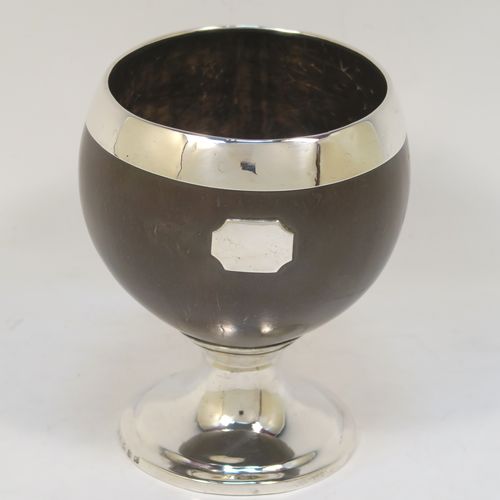 An elegant Antique Georgian Sterling Silver Coconut mounted goblet, with an applied vacant cartouche on one side, a plain round top border, and sitting on a plain round pedestal foot. This handsome antique silver and coconut goblet was made by Charles and David Reid of Newcastle in 1829. The dimensions of this fine hand-made silver and coconut goblet are height 11.5 cms (4.5 inches), and diameter of main body 9.5 cms (3.75 inches).   