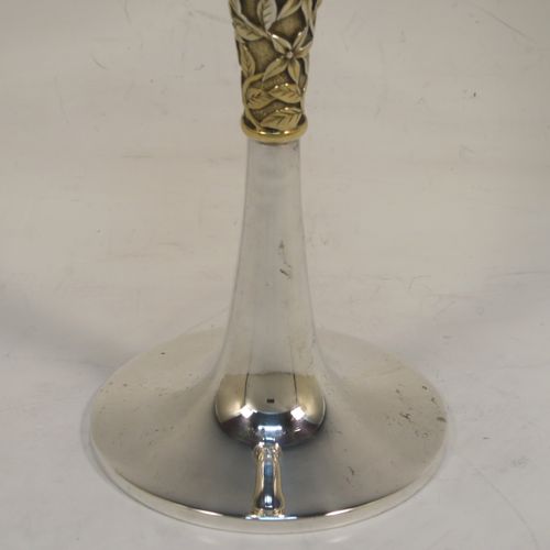 A very elegant Sterling Silver champagne flute goblet, having a plain round tapering body, and sitting on a plain round pedestal foot, with an applied central gold-gilt and florally decorated stem. This beautiful silver champagne goblet flute was made by Peter Nicholas and Co. Ltd., of London in 1987. The dimensions of this fine hand-made silver champagne flute are height 21 cms (8.25 inches), diameter at lip 5.5 cms (2.25 inches), and it weighs approx. 175g (5.6 troy ounces).   