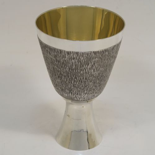 A very unusual modernistic style Sterling Silver sherry or fortified wine goblet, having a round tapering body with a hand-chased bark-like finish, a gold-gilt interior, and sitting on a plain round pedestal foot. This handsome silver sherry goblet was made by RAF of London in 1971. The dimensions of this fine hand-made silver goblet are height 11 cms (4.3 inches), diameter at lip 7.5 cms (3 inches), and it weighs approx. 164g (5.3 troy ounces).  