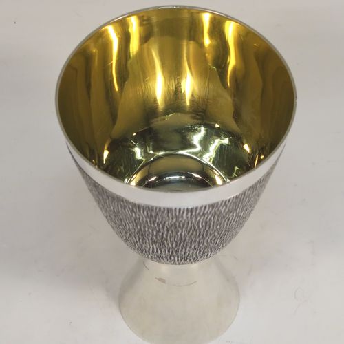 A very unusual modernistic style Sterling Silver sherry or fortified wine goblet, having a round tapering body with a hand-chased bark-like finish, a gold-gilt interior, and sitting on a plain round pedestal foot. This handsome silver sherry goblet was made by RAF of London in 1971. The dimensions of this fine hand-made silver goblet are height 11 cms (4.3 inches), diameter at lip 7.5 cms (3 inches), and it weighs approx. 164g (5.3 troy ounces).  