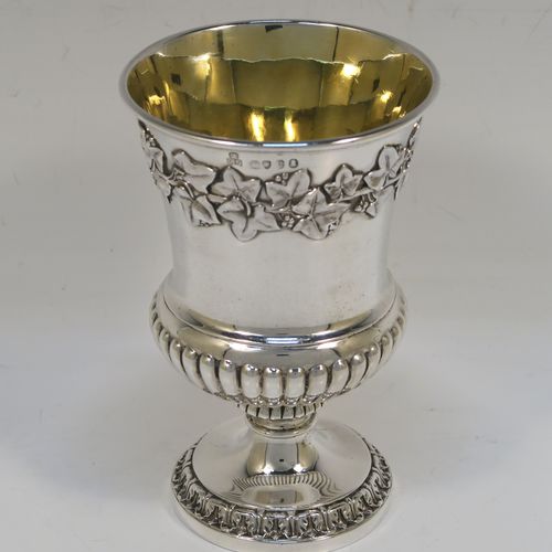 A beautiful Antique Georgian Sterling Silver Regency goblet, having a hand-chased Campagna style body, with an applied band of grapevine decoration, a half-fluted lower body, a gold-gilt interior, and sitting on a pedestal foot. This handsome antique silver Regency style goblet was made by Robert Garrard of London in 1822. The dimensions of this fine hand-made antique silver goblet are height 13.5 cms (5.3 inches), diameter at lip 9 cms (3.5 inches), and it weighs approx. 283g (9 troy ounces).   