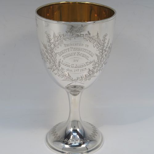 A very pretty Antique Edwardian Sterling Silver goblet, having a round bellied body with hand-engraved floral and gingko leaf decoration, a gold-gilt interior, and sitting on a pedestal foot with matching decoration. This beautiful silver goblet was made by Joseph Gloster of Birmingham in 1906. The dimensions of this fine hand-made antique silver goblet are height 18 cms (7 inches), diameter at lip 9.5 cms (3.75 inches), and it weighs approx. 245g (7.9 troy ounces). Please note that this item has a contemporaneous inscription.