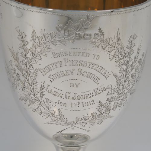 A very pretty Antique Edwardian Sterling Silver goblet, having a round bellied body with hand-engraved floral and gingko leaf decoration, a gold-gilt interior, and sitting on a pedestal foot with matching decoration. This beautiful silver goblet was made by Joseph Gloster of Birmingham in 1906. The dimensions of this fine hand-made antique silver goblet are height 18 cms (7 inches), diameter at lip 9.5 cms (3.75 inches), and it weighs approx. 245g (7.9 troy ounces). Please note that this item has a contemporaneous inscription.