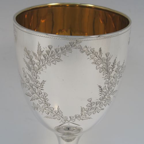 A very pretty Antique Edwardian Sterling Silver goblet, having a round bellied body with hand-engraved floral and gingko leaf decoration, a gold-gilt interior, and sitting on a pedestal foot with matching decoration. This beautiful silver goblet was made by Joseph Gloster of Birmingham in 1906. The dimensions of this fine hand-made antique silver goblet are height 18 cms (7 inches), diameter at lip 9.5 cms (3.75 inches), and it weighs approx. 245g (7.9 troy ounces). Please note that this item has a contemporaneous inscription.