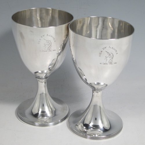 Antique Georgian sterling silver pair of goblets, having plain round bodies, and sitting on pedestal feet with reeded borders. Made by Henry Chawner of London in 1793/94. The dimensions of this fine hand-made pair of silver goblets are height 15 cms (6 inches), diameter at top 8 cms (3.25 inches), and the total weight is approx. 335g (10.8 troy ounces). Please note that both goblets are engraved with crests.