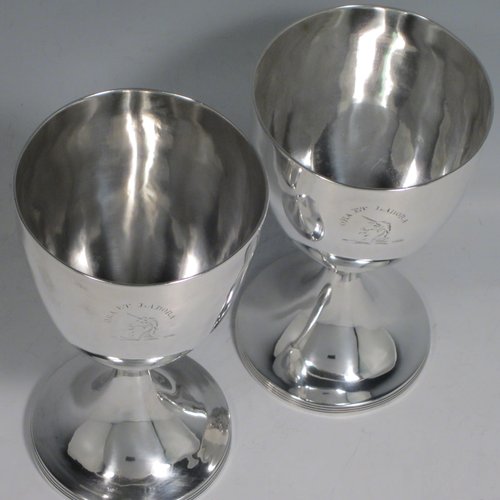 Antique Georgian sterling silver pair of goblets, having plain round bodies, and sitting on pedestal feet with reeded borders. Made by Henry Chawner of London in 1793/94. The dimensions of this fine hand-made pair of silver goblets are height 15 cms (6 inches), diameter at top 8 cms (3.25 inches), and the total weight is approx. 335g (10.8 troy ounces). Please note that both goblets are engraved with crests.