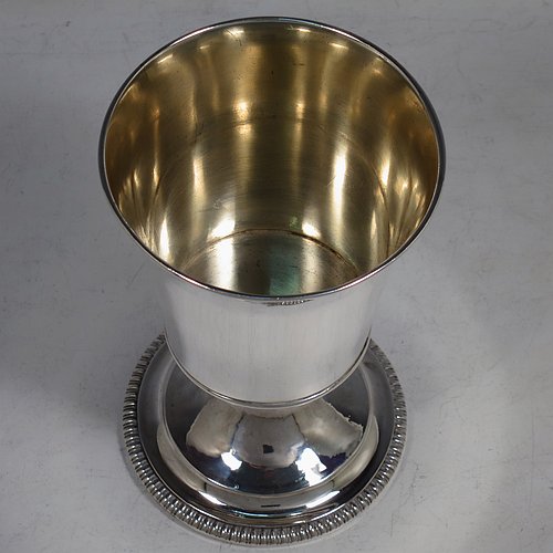 An Antique Georgian Sterling Silver wine goblet, having a plain round tapering body with straight sides, an applied reeded top border, and sitting on a pedestal foot with an applied straight gadroon edge. Made by Henry Nutting & Robert Hennell of London in 1809. The dimensions of this fine hand-made antique silver goblet are height 15 cms (6 inches), diameter at lip 9 cms (3.5 inches), and it weighs approx. 252g (8 troy ounces).    