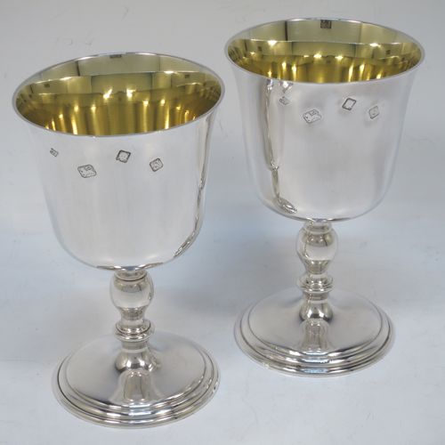 A very handsome Sterling Silver pair of goblets, having plain round tapering bodies with gold-gilt interiors, and sitting on pedestal feet with baluster stems and reeded borders. Made by Trevor Towner of London in 1973. The dimensions of this fine pair of hand-made silver goblets are height 12.5 cms (5 inches), diameter at lip 7.5 cms (3 inches), and they weigh a total of approx. 300g (9.7 troy ounces).   