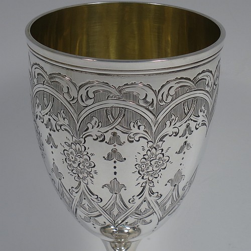 A very pretty Antique Victorian Sterling Silver goblet, having a round bellied body with hand-engraved floral and scroll decoration, with a vacant cartouche on one side, a gold-gilt interior, and sitting on a pedestal foot with hand-engraved decoration and applied bead-edged borders. Made by Henry Wilkinson of London in 1868. The dimensions of this fine hand-made antique silver goblet are height 16.5 cms (6.5 inches), diameter at lip 7.5 cms (3 inches), and it weighs approx. 148g (4.8 troy ounces).    