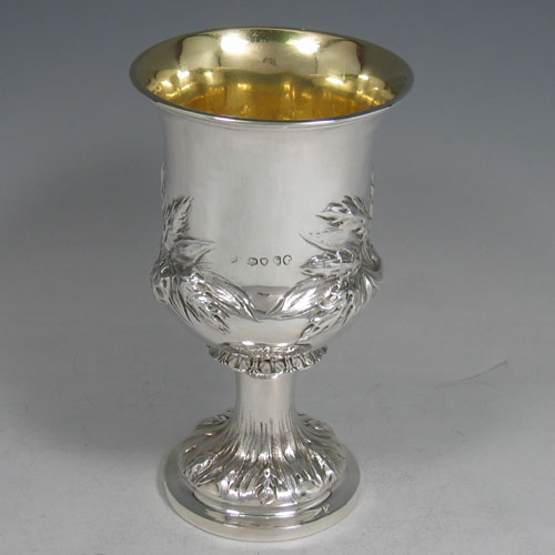 Antique Victorian sterling silver goblet, having a round campagna style body with hand-chased wheat-sheaf decoration, a gold-gilt interior, and sitting on a pedestal foot. Made by George and Charles Fox of London in 1845. The dimensions of this fine hand-made silver goblet are height 15 cms (6 inches), diameter at lip 9 cms (3.5 inches), and it weighs approx. 170g (5.5 troy ounces).
