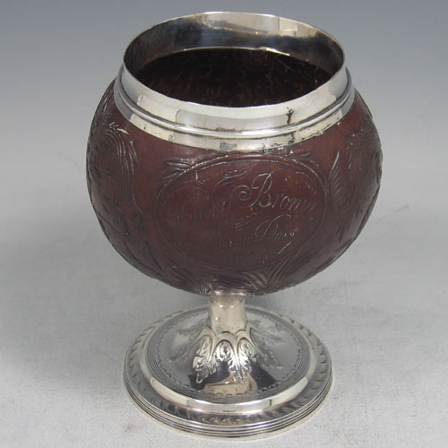 A beautiful Antique Georgian sterling silver Coconut mounted goblet with hand-carved body, a plain top border, and sitting on a plain round pedestal foot. This elegant antique silver and coconut goblet was made by William Penstone III of London in 1802. The dimensions of this fine hand-made silver and coconut goblet are height 14 cms (5.5 inches), diameter at top 6 cms (2.5 inches). Please note that inscription on the carved coconut reads Henry Brown Anno Dom 1771.