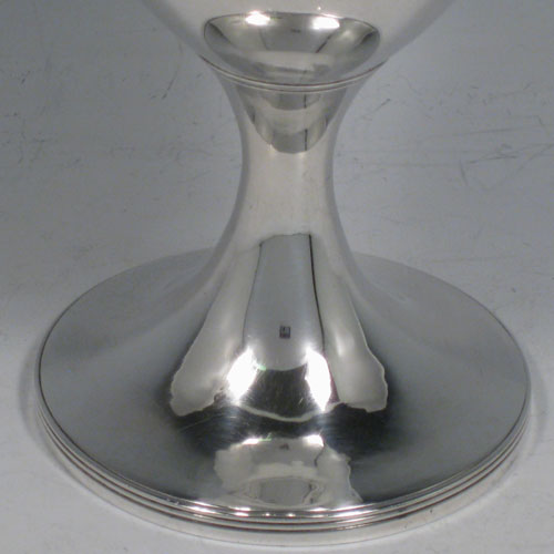 Antique Georgian sterling silver pair of goblets, having plain round bodies sitting on pedestal feet with reeded borders, and vacant laurel leaf cartouches. Made by Soloman Hougham of London in 1802 and presented in a satin and velvet-lined display box. The dimensions of this fine hand-made pair of silver goblets are height 15 cms (6 inches), diameter at top 9 cms (3.5 inches), and the total weight is approx. 445g (14.4 troy ounces).