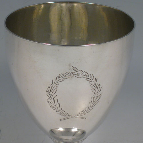 Antique Georgian sterling silver pair of goblets, having plain round bodies sitting on pedestal feet with reeded borders, and vacant laurel leaf cartouches. Made by Soloman Hougham of London in 1802 and presented in a satin and velvet-lined display box. The dimensions of this fine hand-made pair of silver goblets are height 15 cms (6 inches), diameter at top 9 cms (3.5 inches), and the total weight is approx. 445g (14.4 troy ounces).