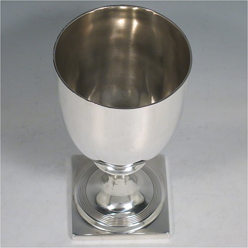 An Antique Georgian Sterling Silver heavy goblet, having a plain round tapering body, and sitting on a pedestal foot with reeded decoration and a square base. Made by Thomas Hayyer of London in 1811. The dimensions of this fine hand-made antique silver goblet are height 17 cms (6.3 inches), diameter at lip 9 cms (3.5 inches), and it weighs approx. 372g (12 troy ounces). Please note that this item is crested.