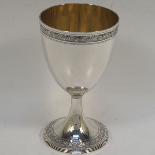 A very pretty Antique Georgian Sterling Silver goblet, having a round tapering body with a top band of hand-engraved floral and scroll decoration, sitting on a pedestal foot with a reeded border and matching engraving, and with a gold-gilt interior. This beautiful antique silver goblet was made John Emes of London in 1804. The dimensions of this fine hand-made antique silver goblet are height 14 cms (5.5 inches), diameter at lip 8 cms (3 inches), and it weighs approx. 158g (5 troy ounces).   