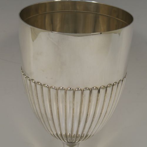 A large and elegant Antique Victorian Sterling Silver goblet, having a round tapering body with hand-chased half-fluted decoration, sitting on a plain round pedestal foot. This handsome antique silver goblet was made by the Deakin Brothers of Sheffield in 1899. The dimensions of this fine hand-made antique silver goblet are height 20.5 cms (8 inches), diameter at lip 10 cms (4 inches), and it weighs approx. 220g (7 troy ounces).   