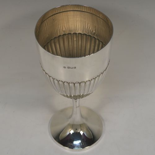 A large and elegant Antique Victorian Sterling Silver goblet, having a round tapering body with hand-chased half-fluted decoration, sitting on a plain round pedestal foot. This handsome antique silver goblet was made by the Deakin Brothers of Sheffield in 1899. The dimensions of this fine hand-made antique silver goblet are height 20.5 cms (8 inches), diameter at lip 10 cms (4 inches), and it weighs approx. 220g (7 troy ounces).   