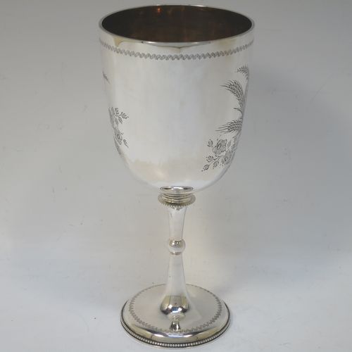 A very pretty Antique Victorian Sterling Silver goblet, having a round straight-sided and bellied body with hand-engraved floral and wheat-sheaf decoration, with a vacant cartouche on one side, a gold-gilt interior, and sitting on a pedestal foot with hand-engraved decoration and an applied bead-edged border. Made by George Maudsley Jackson of London in 1892. The dimensions of this fine hand-made antique silver goblet are height 18.5 cms (7.3 inches), diameter at lip 8.5 cms (3.3 inches), and it weighs approx. 175g (5.6 troy ounces).  