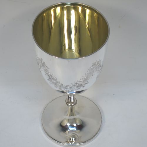 A very pretty Antique Victorian Sterling Silver goblet, having a round bellied body with hand-engraved swags of floral decoration, a gold-gilt interior, and sitting on a pedestal foot with an applied bead-edged border. Made by James Dixon and Sons of Sheffield in 1877. The dimensions of this fine hand-made antique silver goblet are height 18 cms (7 inches), diameter at lip 8.5 cms (3.3 inches), and it weighs approx. 224g (7.2 troy ounces).  