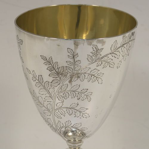 A very pretty Antique Victorian Sterling Silver goblet, having a round bellied body with hand-engraved tree and leaf floral decoration, a gold-gilt interior, and sitting on a pedestal foot with an applied double bead-edged border. This beautiful silver goblet was made by Thomas Smiley of London in 1870. The dimensions of this fine hand-made antique silver goblet are height 16.5 cms (6.5 inches), diameter at lip 8 cms (3.25 inches), and it weighs approx. 172g (5.5 troy ounces).   