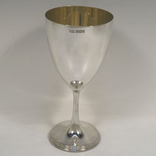 An elegant Antique Victorian Sterling Silver wine goblet, having a plain round body, a gold-gilt interior, and all sitting on a pedestal foot with an applied bead-edged border. This handsome antique silver wine goblet was made by Henry Wilkinson of Sheffield in 1898. The dimensions of this fine hand-made silver goblet are height 19 cms (7.5 inches), diameter of body at lip 9 cms (3.5 inches), and it weighs approx.202g (6.5 troy ounces).   