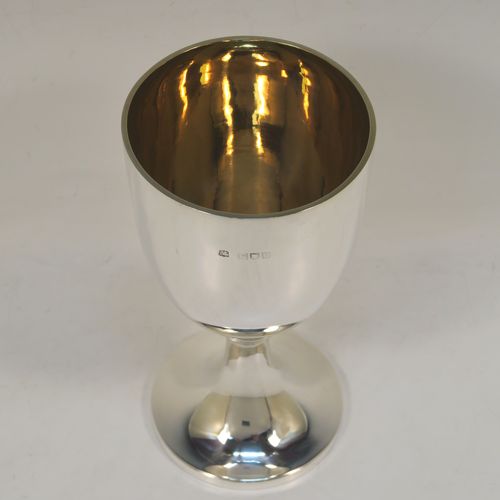 A very handsome Antique Victorian Sterling Silver goblet, having a plain round tapering body with a gold-gilt interior, and sitting on a pedestal foot with an applied upper reeded band. This elegant antique silver wine goblet was made by the Harris Brothers of London in 1897. The dimensions of this fine hand-made antique silver goblet are height 18 cms (7 inches), diameter at lip 9 cms (3.5 inches), and it weighs approx. 257g (8.3 troy ounces). Please note that this item is crested on one side. 