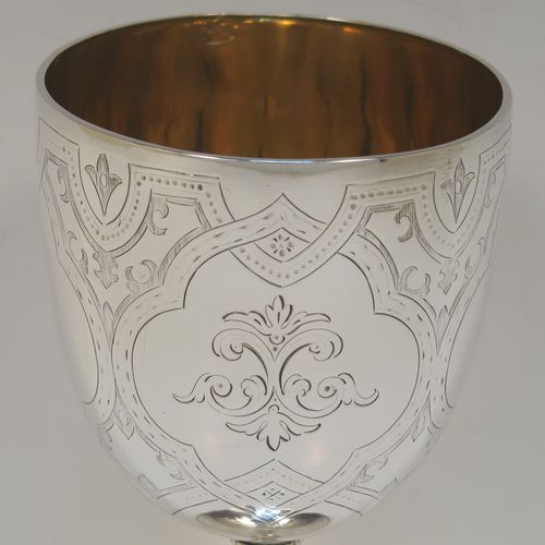 A pretty Antique Victorian Sterling Silver goblet, having a round bellied body with hand-engraved floral and scroll decoration, a gold-gilt interior, and sitting on a pedestal foot with hand-engraved decoration and an applied bead-edged border. This beautiful silver goblet was made by Henry Holland of London in 1870. The dimensions of this fine hand-made antique silver goblet are height 16.5 cms (6.5 inches), diameter at lip 8.5 cms (3.3 inches), and it weighs approx. 188g (6 troy ounces).   