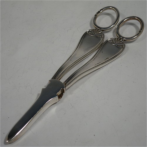 A very handsome and heavy Sterling Silver pair of grape shears or scissors in a double struck pattern with reeded borders and shell and scroll terminals. Made by Charles Boyton and Sons of Sheffield in 1931. The dimensions of this fine hand-made pair of  silver grape scissors or shears are length 18 cms (7 inches), and they weigh approx. 123g (4 troy ounces).    