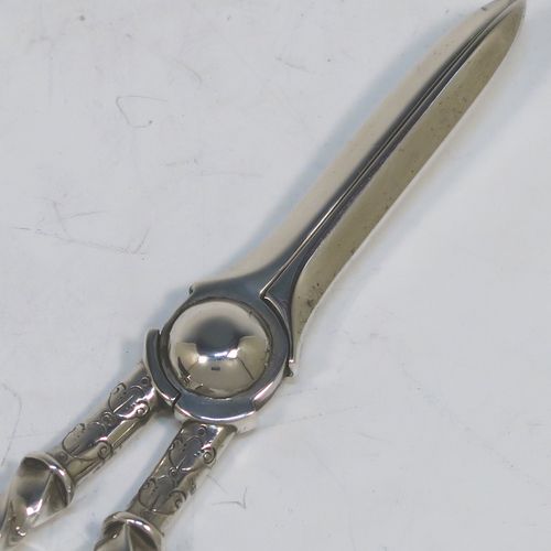 A very pretty Antique Victorian Sterling Silver pair of grape shears or scissors, with cast handles in a twisted style, with plain loop handles and hand-chased terminals, all in its original maroon velvet and stain-lined presentation box. This beautiful pair of antique silver grape scissors were made by Edward Hutton  of London in 1889. The dimensions of this fine hand-made pair of antique silver grape shears are length 17.5 cms (7 inches), and they weigh approx. 109g (3.5 troy ounces).  