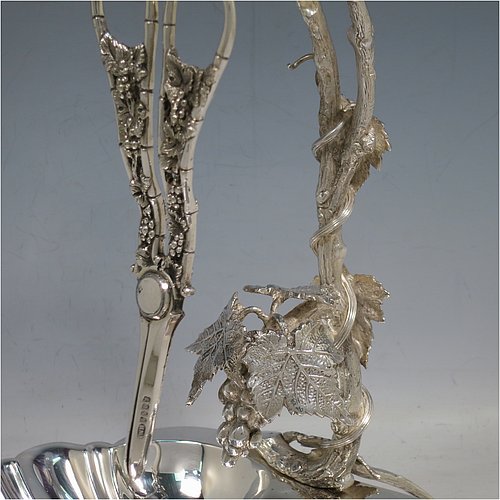 An Antique Victorian silver-plated grape dish stand with a pair of original grape shears in the Grapevine pattern, with cast vine-leaf tendrils, and a shell-style dish, sitting on three ball feet. All made by William Hutton & Sons of Sheffield in ca. 1880. The dimensions of this fine hand-made antique silver plated grape dish stand and scissors are height 27 cms (10.5 inches), width 25.5 cms (10 inches), and length 25.5 cms (10 inches).   